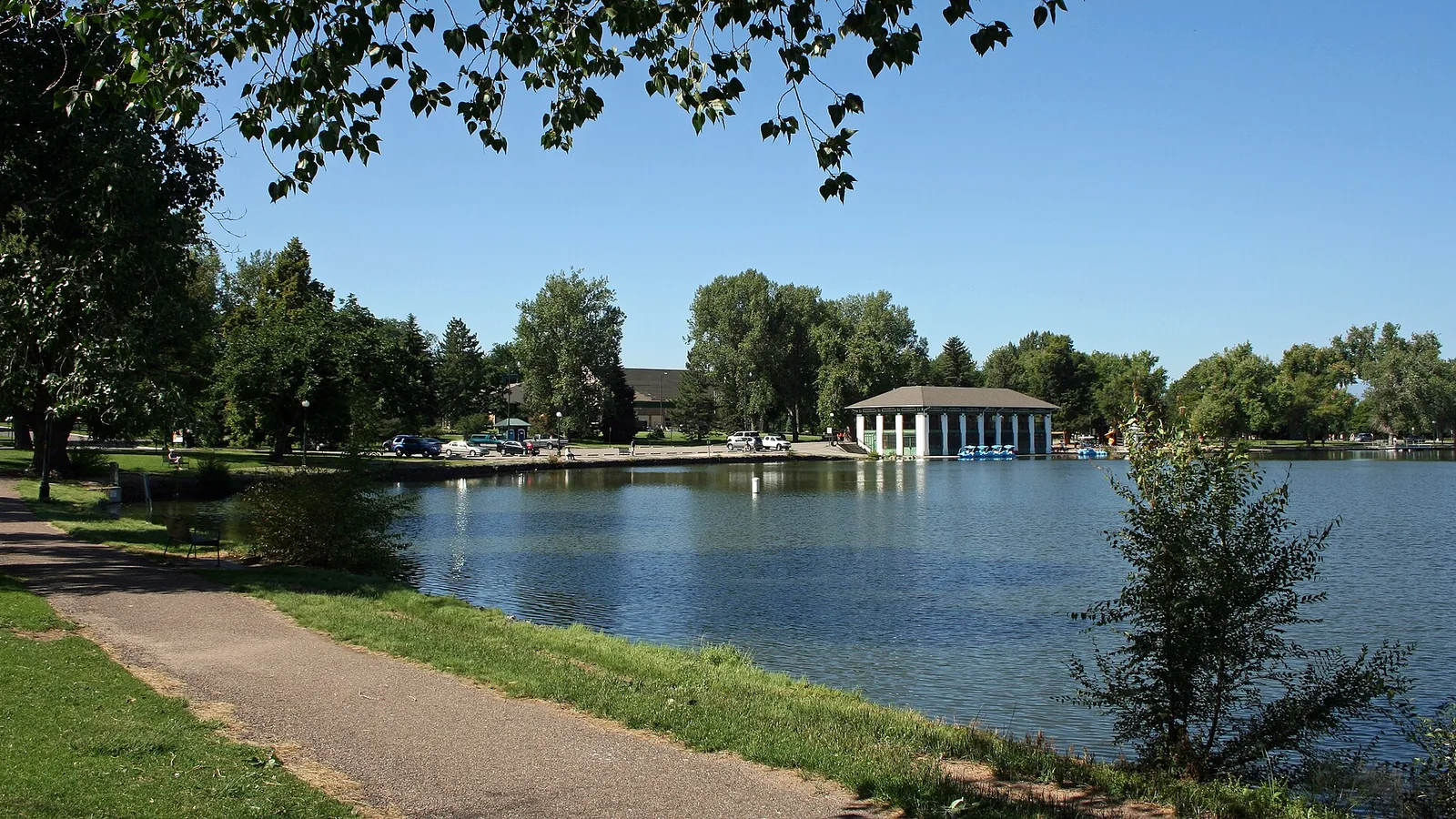 Washington Park Denver with lake, jogging paths, cyclists, and historic homes surrounding the park